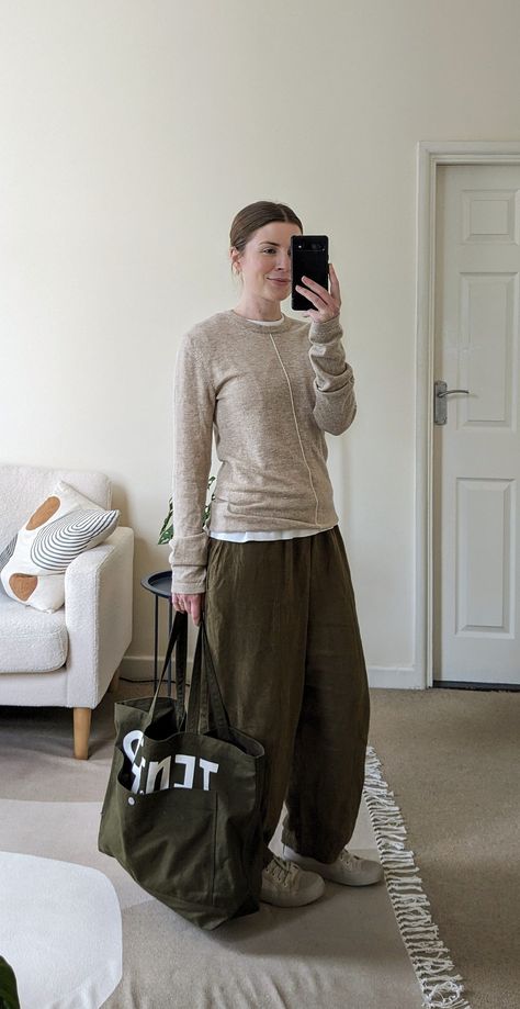 A woman stands in front of a mirror. She wears a beige jumper, khkai green trousers, white canvas shoes and she carries a green canvas tote bag. Chic Comfortable Travel Outfit, Clothes For Long Haul Flight, Flight Jacket Outfit Women, Long Haul Flight Outfit Winter, What To Wear On Long Haul Flights, Flight Jacket Outfit, Osaka Outfit, Long Haul Flight Outfit, Long Flight Outfit