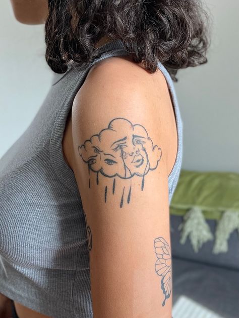 Picture of a crying cloud tattoo on the upper arm Cloud Lady Tattoo, Upper Arm Tattoo Aesthetic, Arm Tattoo Inspo Aesthetic, Mystic Eye Tattoo, Cloud Tattoo Aesthetic, Cloud With Eyes Tattoo, Cloud With Face Tattoo, Cloud Tattoo Women, Cloud Tattoo Color