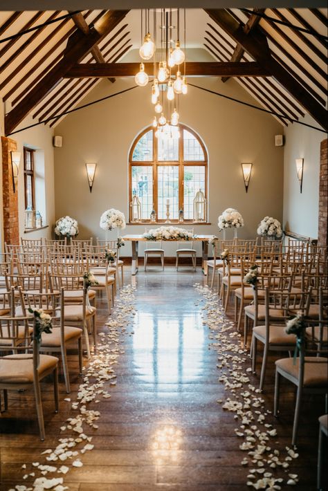 Beautiful aisle decor - white rose petals line the aisle with rose and gypsophilia bunches tied to the chairs - large displays either side of ceremony table with a long low display - nuthurst grange wedding venue - penny johnson flowers coleshill White Roses Aisle Decor, Petal Isle Wedding, Wedding Aisle Flower Petals, Rose Petal Wedding Aisle, Indoor Wedding Aisle Decor, White Rose Petals Down Aisle, Rose Petals Down Aisle, Wedding Aisle Petals, Indoor Wedding Aisle