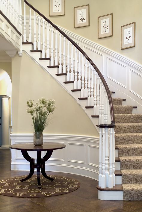 A curved interior staircase adds grace and elegance. Colonial House Staircase Ideas, Curved Staircase Runner, 80s Staircase, Curved Staircase Foyer Entryway, Curved Staircase Foyer, Colonial Staircase, Mahogany Floors, Decorating Stairway Walls, Stairway Ideas