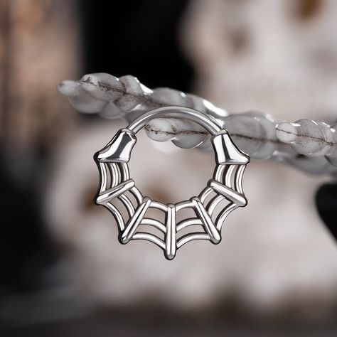 This spider web septum ring is sleek and symmetrical. Without too many embellishments, this piece of jewelry emanates a sense of simplicity and minimalism. It can fit into the modern fashionable trends effortlessly. You can also wear it during the Halloween season, dressing up in a spooky style matching all of these cute pieces of jewelry is such a delight. Spider Septum Ring, Punk Septum Piercing, Alt Septum Jewelry, Spiderweb Septum, Goth Septum Jewelry, Gothic Septum Jewelry, Cool Septum Piercing, Cute Septum Piercing Jewelry, Septum Ring Aesthetic