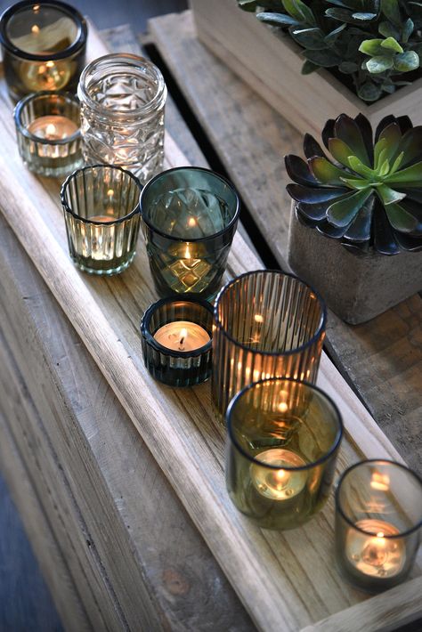 Glass Tealight Candle Holders With Wood Tray This unique votive holder set features various shape and size glass tealight holders and a weathered wood base! Includes 9 glass candle holders and wood base Dimensions: 22" Long x 5 1/2" Wide Does not include candles #gift #candlelight #happy #candle #candlelover #decoration #light #homedecor #decor #home #candlesofinstagram #instagood #love #candles #woodwaves Simple Moody Centerpieces, Glass Box Candle Holder, Greens And Candles Wedding, Simple Earthy Wedding Decor, Candle Centerpiece Dining Table, Manly Table Decor, Music Theme Table Centerpieces, Colored Glass Centerpiece Wedding, Vintage Glass Centerpieces Wedding