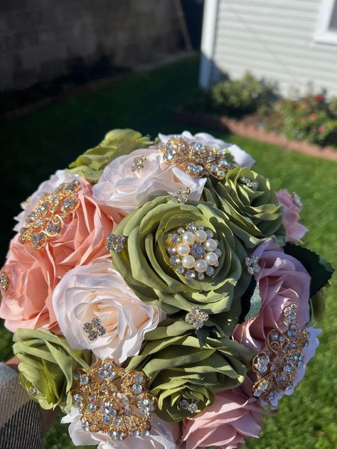 Handmade Quinceañera Bouquet/ Wedding.  With Sage Green, Blush and Ivory Roses. Finished off with Gold brooches.  *Please note brooches can change in style due to availability.* Decor / color combinations can be changed upon request. {This is a made to order Bouquet} Sage Green With Pink Quinceanera Dresses, Sage Green Quince Dress With Pink Flowers, Sage Green Ramos, Sage Green And Pink Quinceanera Dresses, Sage Green And Blush Quinceanera, Green And Gold Birthday Theme, Sage Green Quince Bouquet, Green And Pink Sweet 16 Theme, Sage Green Quinceanera Ramo