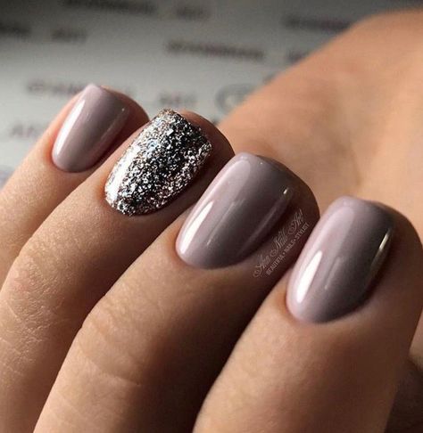 Beautiful manicure with a purple-based mauve-gray color, and a sparkly silver accent nail. Perfect for the holidays. Simple Nails With Glitter Accent, Gray And Sparkle Nails, Neutral Manicure With Accent Nail, Nail Colors With Accent Nail, Muted Lavender Nails, Fall Nails Sparkle Accent, Best Nails For Wedding Guest, Short Oval Glitter Nails, November Dip Nails 2023