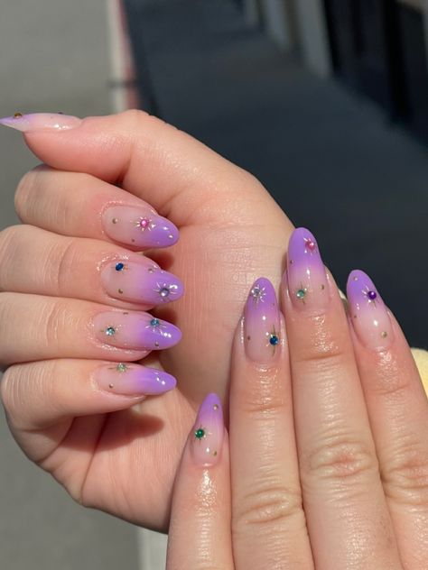 Lavender airbrush gel manicure with a nude base. Gold stars with multicolor rhinestones over top. Lavender Star Nails, Nude Base Nail Designs, Lavender And Gold Nails, Purple Star Nails, Gemstone Nail Art, Nail Art Stars, Anniversary Nails, Celestial Nails, Star Nail Designs