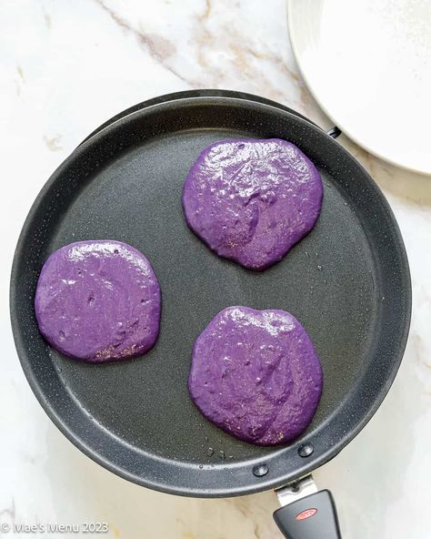 Ube pancakes bring a brilliant purple color and sweet nutty vanilla flavor to your plate or party spread. These purple pancakes are easy to make and deliver on both taste and uniqueness. Purple Pancakes, Ube Pancakes, Ube Extract, Wonka Movie, Sweet Pancakes, Silver Dollar Pancakes, Cozy Brunch, Pancake Warmer, Pancake Toppings