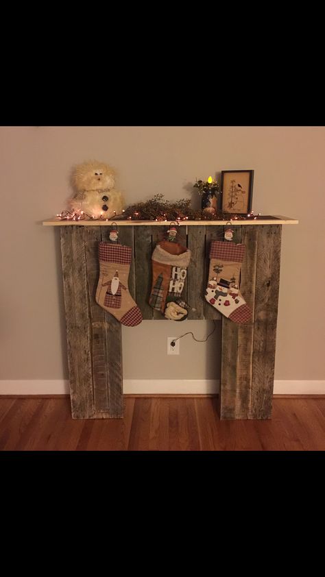 Faux fireplace made from wood pallets. Finally a place to hang our stockings! Thanks hubby! Pallet Mantle, Fake Fireplace Diy Easy Christmas Decor, Faux Fireplace Cardboard, Diy Fake Fireplace Cardboard, Faux Fireplace Diy Cardboard Christmas, Pallet Fireplace, Farmhouse Rustic Faux Wood Presents, Diy Christmas Fireplace, Faux Fireplace Diy