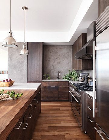 Rich walnut cabinets by Robert Bakes lend a warm, inviting atmosphere to the kitchen of a modern house by designer Alexandra Fazio of Cecil Baker & Partners. The backsplash is hand-troweled plaster, made to look like an old concrete wall. Modern Konyhatervezés, Modern Wood Kitchen, Walnut Kitchen, Kabinet Dapur, Walnut Cabinets, Interior Design Magazine, Interior Modern, Stainless Steel Appliances, Counter Tops