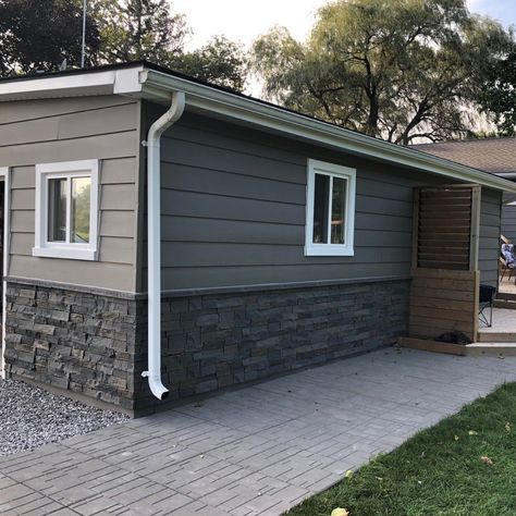 Our faux stone panels can be used indoors or out, and this beautiful blend of both grey and brown in our Ledge Stone profile works seamlessly for either. Whether being used as house skirting or around a fireplace, you're sure to have a stunning finish. No matter if your walls are bare or wallpapered, Quality Stone Faux Stone Panels will instantly give your surfaces style and character. Each Quality Stone Faux Panel is hand painted ensuring that there isn’t a repeating pattern. They are built to House Skirting Ideas Exterior Stone, Faux Stone Deck Skirting, Vinyl And Stone Exterior, Faux Rock Siding Exterior, Exterior Faux Stone Panels, Faux Brick Siding Exterior, Rock Siding On House, Skirting For Homes, Fake Stone Exterior