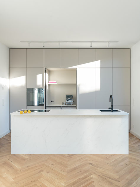 As part of the renovation of an old building in the traditional old town of Soest, a modern extension was added, which, like the kitchen, blends in well with the charming surroundings. The kitchen has some exciting details, such as the slideaway bar, which can be hidden behind the pocket doors if required, and the free-floating and slightly rounded counter at the back of the cooking element. The ultra-matt gray/beige fronts interact with the marbled ceramic to create a harmonious overall look. Modern Extension, Pocket Doors, Old Building, New Project, Kitchen Counter, Old Town, The Kitchen, Doors, Design