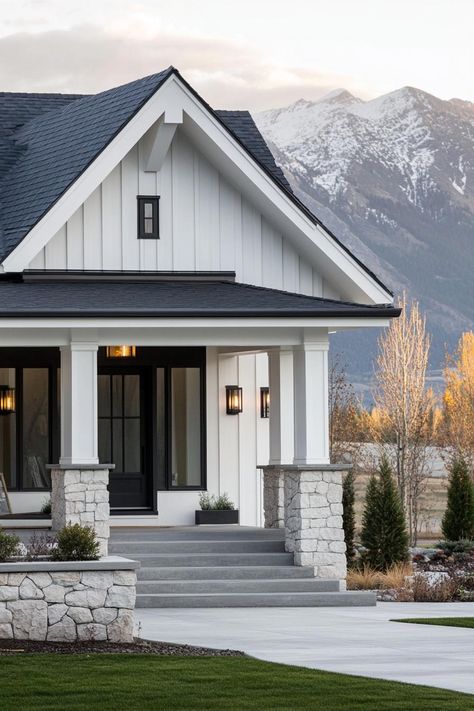 Modern cottage style mountain house facade with white stone foundation white clapboard siding concrete porch with stone and grey wood columns grey. Check out all of these modern white mountain houses, combining sleek designs with nature’s majesty to create stunning havens. White House With Grey Trim, White House With Stone, White Siding House, Stone Foundation, Hardy Plank Siding, Siding Styles, Modern Cottage Style, Sustainable House Design, Grey Siding