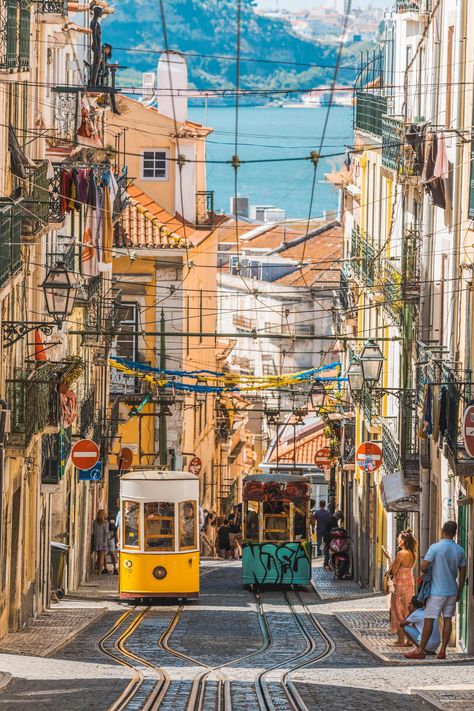 Lisbon has many stunning sites, but perhaps the best place to take it all in is along the city's famous Elevador da Bica. Pedestrians who walk (or ride) to the top of the steep incline will be greeted with dramatic views of the narrow street, cable cars running on their tracks, and further, the Tagus River. Many of the streetcars are painted by local street artists, adding more urban beauty and grittiness to the picturesque landmark. Capital Cities, Lisbon Travel, Sintra Portugal, Beautiful Streets, Voyage Europe, Portugal Travel, Famous Places, Best Cities, City Streets