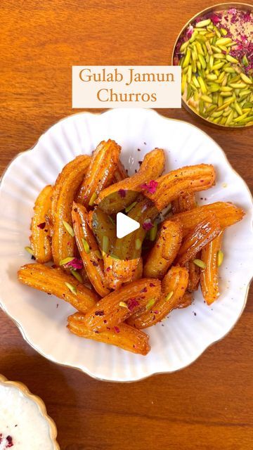 Guntas Sethi on Instagram: "✨Gulab Jamun Churros✨

Churros with a desi twist, Gulab Jamun you can’t resist! 🍯✨ 

These bite-sized beauties are the perfect fusion of classic churros and our favourite Indian sweet. Whether it’s a cozy family gathering or a festive celebration, these mini delights are sure to impress, especially when served with Rabri. It tastes divine! 🤤

Recipe: 

-1 cup Water 
-1 Tbsp Milk 
-1 tbsp sugar 
-2 tbsp butter 
-1 cup Flour 
- 2 tbsp milk powder

For instant Rabdi 

-500 ml Milk 
-7/8 Saffron strands 
-2 bread slices into crumbs 
-1/2 cup Condensed milk 
-Dried rose petals 

Sugar syrup 

-1/2 cup Castor sugar 
-1.5 cup water 
-1 tsp Cardamom powder 
-7/8 Kesar strands

#gulabjamunchurros #fusionrecipe #gulabjamun #festiverecipes #homemade

[Gulab Jamun Churros Milk Sweets Indian, Dry Gulab Jamun Recipe, Fiji Gulab Jamun Recipe, Instant Gulab Jamun Recipe, Dessert With Gulab Jamun, Custard Gulab Jamun, Gulab Jamun Fusion Dessert, Diwali Party, Gulab Jamun