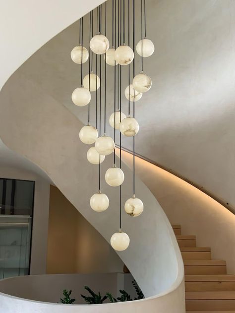 The Alabaster Balls Cluster Chandelier is a modern masterpiece, designed to add a touch of divine elegance to your space. Featuring a series of glowing Alabaster Balls suspended in a layered formation on a smooth circular canopy, each of the orbs is meticulously crafted to exude a soft ambient glow cascading down in an elegant array. With its delicate design, this cluster chandelier is a centerpiece in any room, perfect for creating a refined and peaceful atmosphere. Whether illuminated or not, Feature Lighting Pendant, Modern Organic Chandelier, Cement Pendant Light, Chandelier Kitchen, Cluster Chandelier, Alabaster Lamp, Large Ceiling Fans, Recessed Wall Lights, Arc Lamp