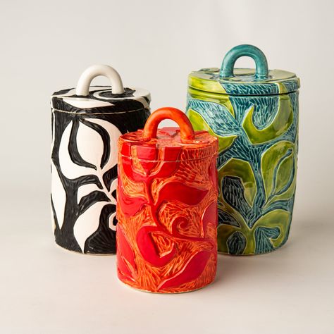 "Kitchen Canister Set of Three - Handcarved Ceramic We asked local potter Monte Young (etsy shop Monte Young Pottery) to throw these stoneware vessels for us. We then carved these bold patterns into the raw clay then bisque fired them, glazed them with our favorite palette of bright colors, and fired them again.   Pretty addition to kitchen countertop as a canister or cookie jar or by itself adds cheery personality to a space.  The inside of each vessel is functional and food safe.  MADE TO ORDER Each piece is a handcrafted one-of-a-kind piece. Our pictures represent a close color palette of the glazed stoneware and semiprecious stones as well as the typical shape and size variations. The item you receive will be very similar to the item photographed but may vary in coloration and design. Easy Pottery Projects, Functional Pottery Ideas, Autumn Ceramics, Pottery Canisters, Funky Ceramics, Eclectic Ceramics, Textured Ceramics, Pottery Canisters Handmade, Ceramic Containers With Lids