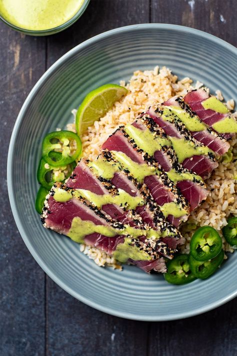 Pan seared ahi tuna has always been one of my favorite seafood dishes. My recipe features a sesame crusted ahi tuna (yellowfin or bigeye) that is crispy on the outside with a melt-in-your-mouth, raw interior. If you're a sushi lover, this recipe is absolutely for you. I like to serve pan seared tuna over jasmine or brown rice and top with both spicy cilantro-lime aioli and soy sauce. #pansearedtuna #searedtuna #ahituna #sesamecrustedtuna Cilantro Lime Aioli Recipe, Ahi Recipes, Seared Ahi Tuna Recipe, Tuna And Rice, Seared Tuna Recipe, Sesame Seared Tuna, Tuna Steak Recipe, Ahi Tuna Steak Recipe, Sesame Crusted Tuna