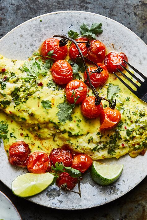 NYT Cooking: A coconut-milk dressing infused with garlic, ginger, turmeric and lime coats fish fillets in this sheet-pan dinner. Accompanying the fish are bright bursts of tomatoes which turn jammy under the broiler and relinquish some of their juices to the pan sauce. This sauce is silky enough to coat a spoon and packed with flavor. It pairs well with anything from snapper to flounder and even salmon, so ... African Books, Baked Tomato Recipes, Tomato Bake, Coconut Fish, Baked Tomatoes, Nyt Cooking, Baked Fish, Fish Fillet, Fish Dishes