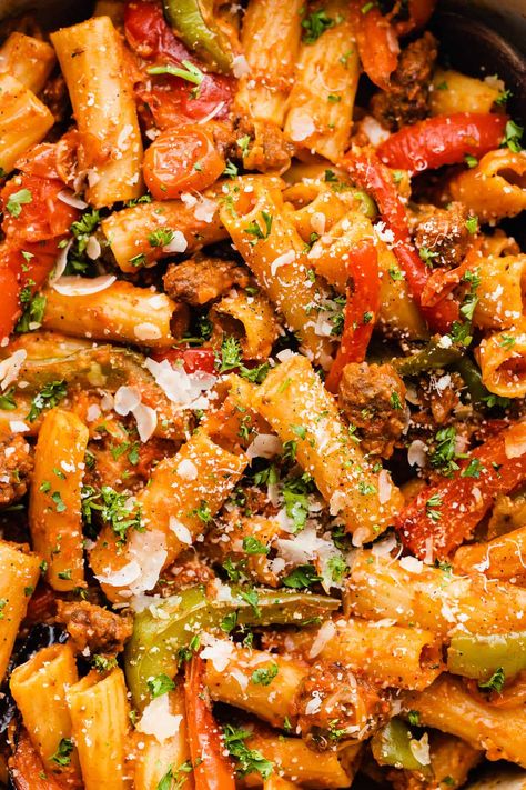 This pasta dish is one of our all-time favorite weeknight meals! It's made with plenty of roasted bell peppers and tomatoes, with some getting blended into a sauce for extra heartiness. Toss your veggies and rigatoni together with plenty of sausage, sauce, and parmesan cheese for an easy and impressive dinner everyone will love! #rigatoni #weeknightpasta #roastedredpeppers #bellpeppers #italiansausage #easydinnerrecipes #mealpreprecipes #bluebowlrecipes | bluebowlrecipes.com Roasted Red Pepper And Tomato Pasta, Roasted Bell Pepper Pasta, Roasted Red Pepper Rigatoni, Rigatoni Sausage, Bell Pepper Pasta, Rigatoni Pasta Recipes, Burst Tomatoes, Roasted Bell Peppers, Sausage Parmesan