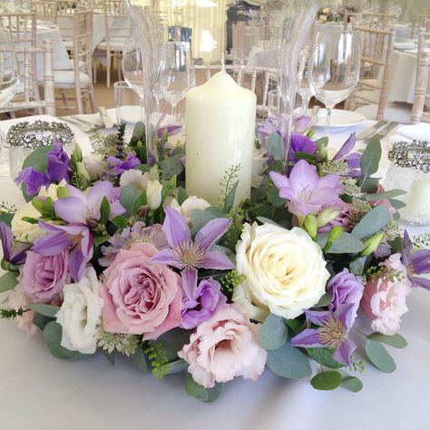 Floral ring with hurricane vase and candle. Lilac flowers. Diy Wedding Centerpieces Round Tables, Purple Centerpiece Wedding, Lilac Centerpieces, Wedding Table Centerpieces Purple, Purple Flower Centerpieces, Elegant Table Centerpieces, Purple Wedding Centerpieces, Purple Centerpieces, Candle Arrangements