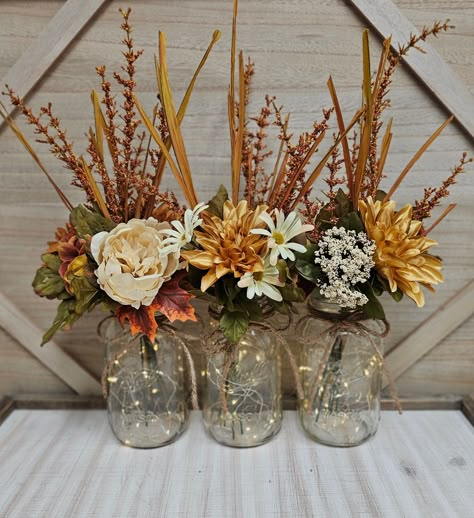 These beautiful 3 piece quart size mason jar centerpiece set includes three sets of warm white LED fairy lights, three jute bows, and three deluxe faux fall arrangements. These centerpieces are very popular for weddings, baby showers, parties, corporate events, holiday events, and any other event that requires table centerpieces. They also look great in any room of your house or office. To see other lighted jar options and all of my other listings, please view my shop: https://www.etsy.com/shop/ Mason Jar Decorations For Weddings, Fall Birthday Centerpieces For Table, Fall Color Birthday Decorations, Centerpieces That Are Not Flowers, Tall Fall Centerpieces Wedding, Fall Color Party Decorations, Fall Baby Shower Centerpieces For Girl, Mason Jar Fall Centerpieces, Mason Jar Centerpieces For Weddings