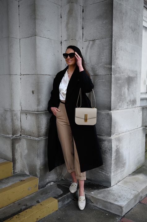 Wearing the Vancouver cross-body bag in a stunning taupe-coloured smooth leather from DeMellier London. Stone-coloured trousers complimented with a gold clasp black leather belt, on top a white silk bow tie blouse for added texture. Wrapped up in Other Stories belted wool coat in black. The look is completed with some neutral sophisticated leather loafers. #DeMellierLondon #DeMellierBag #Luxury #LuxuryHandbag #LuxuryCrossbodyBag #Taupe #TaupeBag #LuxuryStyling #ootd #designerbag Demellier Vancouver Bag, Taupe Purse Outfit, Demellier Vancouver Bag Outfit, Demellier Bags Outfit, Taupe Bag Outfit, Chloe Marcie Bag Outfit, Demellier Bags, Demellier London, Demellier Vancouver