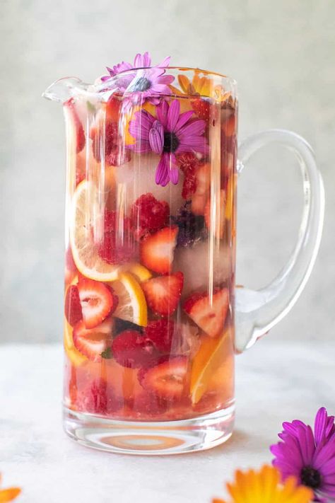 This floral sangria recipe is made with white wine and elderflower liqueur. It's regressing, light, fruity with the most beautiful floral notes throughout. It's refreshing and perfect for spring. #Sangria #WhiteSangria #FloralSangria #SangriaRecipe #Cocktails #SpringCocktails #WineCocktails Floral Sangria, Spring Sangria, Limonade Bar, Sparkling Sangria, White Sangria Recipe, Easy Sangria Recipes, Floral Brunch, Sangria Ingredients, Spring Food