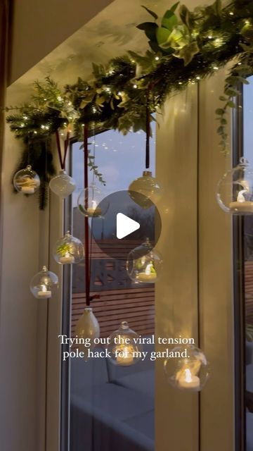 23K views · 1.2K likes | Ashley | Home Interiors, Garden & DIY on Instagram: "Anyone else still adding to their Christmas decorations? I decided on a whim to add my hanging tea lights to the windows this year rather than above my dining room table. So I grabbed one of those tension poles and wrapped it with left over garlands and baubles. I hung them using clear wire to give them a floating effect. The remote comes in so handy to turn the tea lights on/off. 

Tension pole from @dunelmuk 

#diningroom #christmasdinnertable #christmasfaffing" Hanging Christmas Decor Over Dining Table, Hanging Candles Christmas, Above Window Christmas Decor, Garland Above Window, Tension Rod Christmas Garland, Christmas Window Decorations With Lights, Christmas Window Garland, Window Garland Christmas, Window Garland