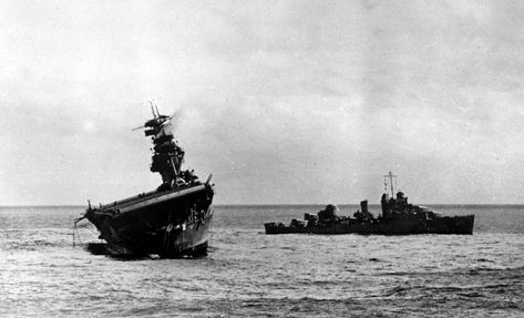 The USS Yorktown lists heavily to port after being struck by Japanese bombers and torpedo planes in the Battle of Midway on June 4, 1942. A destroyer stands by at right to assist as a salvage crew on the flight deck tries to right the stricken aircraft carrier. Battle Of Midway, Uss Yorktown, Navy Aircraft Carrier, Us Navy Ships, Historia Universal, Naval History, Navy Aircraft, Wwii Aircraft, Pearl Harbor