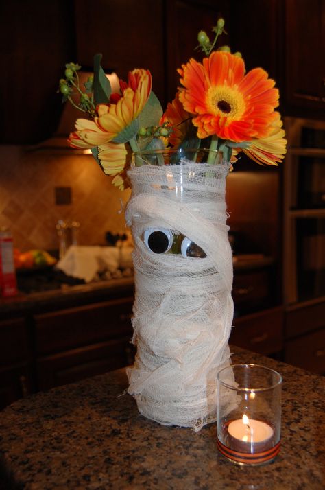 my mummy flower arrangement using cheesecloth and a pair of googlely eyes Diy Halloween Flower Bouquet, Halloween Fresh Flower Arrangements, Diy Halloween Flower Arrangements, Halloween Flowers Arrangements, Halloween Flower Arrangements Diy, Halloween Centerpiece Ideas Party, Spooky Flower Arrangements, Halloween Flower Bouquet, Halloween Arrangements