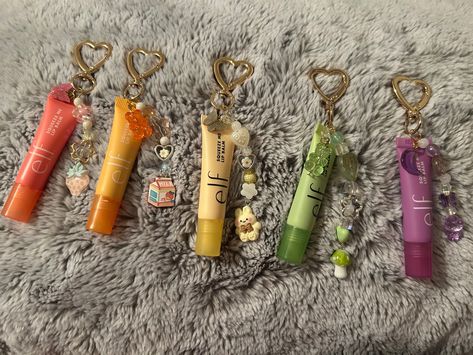 Cutie elf lipgloss keychains  Available for customization ✨ Elf Lip Gloss Keychain, Gift To Give To Your Best Friend, Chapstick Charms, Elf Lip Balm Keychain, Unique Lip Gloss Tubes, Gifts To Make For Best Friends, Lip Gloss With Charms, Lipgloss Keychain Diy, Elf Lipgloss