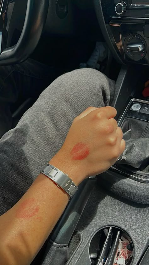 A male arm holding the steering stick of a car is covered with red lipstick kisses. The arm also wears a Casio watch Lipstick Kisses Boyfriend Aesthetic, Secret Couple Picture Ideas, Lipstick Marks On Boyfriend Aesthetic, Red Lipstick Kisses Boyfriend, Secret Photos With Boyfriend, Couple Lipstick Mark, Lipstick On Boyfriend Face, Kiss Marks On Boyfriend, Secret Boyfriend Photos Aesthetic