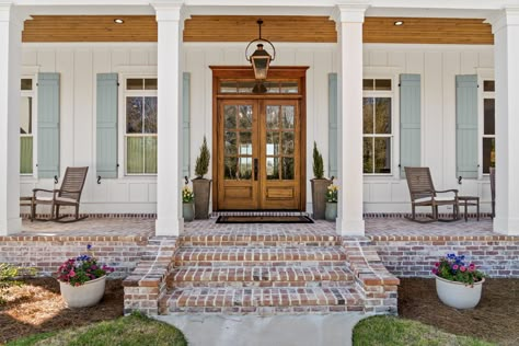 This entryway creates an energy of warmth, elegance, and timelessness as it captures beautiful simplicity of traditional cottage character. From the symmetry to its tall windows and spacious porch, this cottage is endlessly welcoming.   Designed by Bob Chatham Custom Home Design Built by Frostholm Construction LLC Photography by Bailey Chastang White House Brick Porch, French Country Front Door Ideas, Brick Steps Front Porch, French Country Front Porch Ideas, French Country Exterior Homes, Porch Details, Country House Exterior, White Bungalow, Country Home Exterior