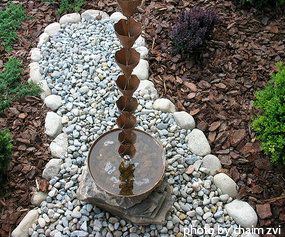 Copper rain chain hanging into copper hammered basin filled with water on rock bed, decorative rain chains, unique rain chains. Rain Gutter Chains, Gutter Chains, Water Chain, Rain Catcher, Copper Rain Chains, Landscape Drainage, Outdoor Makeover, Chain Ideas, Rock Bed