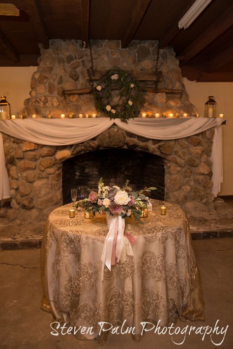 Rustic Tucson wedding at Corona Ranch. Desert Dove theme - plum, mauve, sage, gray. Rustic and romantic head table and mantle decor with drapping, tea lights, succulent wreath and lanterns.  Tucson wedding florist design by A Floral Note. Vendella and Amnesia roses, peonies, succulents, snapdragons, acacia, eucalyptus, olive, astrantia, dusty miller,  & majolika spray roses.    Design by POM Events. Photos by Steven Palm Photography. Floral design by A Floral Note. Diy Wedding Mantle Decorations, Mantle Decorating Ideas Wedding, Mantel Decorating Ideas Wedding, Wedding Fireplace Decor, Wedding Mantle, Palm Photography, Renewal Vows, Wedding Fireplace, Tucson Wedding