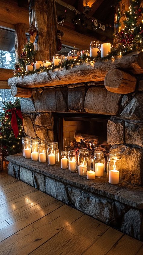 Rustic stone fireplace with glowing glass candle jars and festive decorations, creating a cozy holiday ambiance in a Mountain Stone Fireplace, Floor Decor In Front Of Fireplace, Fireplace With Candles Inside, Fireplace Candles Inside, Cozy Christmas Mantle, Fireplace With Candles, Christmas Mantle Ideas, Holiday Fireplace Decor, Mantle Decorating Ideas