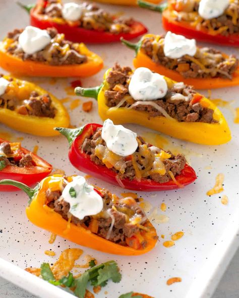 Mini Taco Stuffed Peppers stuffed with taco meat, cheese, and drizzled with a cilantro cream sauce. #mini #taco #stuffed #peppers #recipe Taco Stuffed Mini Peppers, Chicken Stuffed Mini Peppers, Stuffed Mini Peppers With Ground Beef, Mini Peppers Stuffed With Cream Cheese, Mini Bell Pepper Recipes, Stuffed Peppers Taco, Stuffed Mini Sweet Peppers, Cilantro Cream Sauce, Aldi Meals