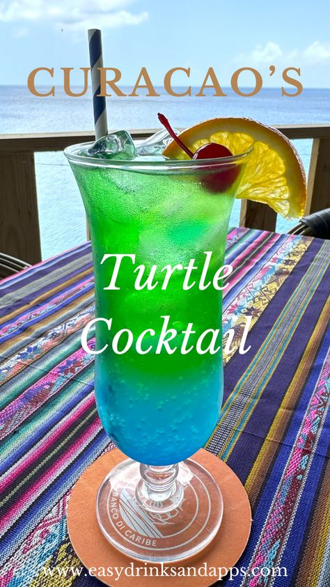 The Turtle Cocktail from Playa Forte Restaurant in Curacao is a must-try. With its enticing blue and green hues, this vibrant drink combines vodka, blue and green curaçao, lemon juice, and ginger ale, offering a refreshing twist perfect for a tropical setting.  Playa Forte Restaurant is known for its scenic beachside location and menu that captures the essence of Caribbean cuisine. Inspired by the island’s love for sea turtles, the Turtle Cocktail has become a signature drink. Drinks With Ginger Ale, Turtle Cocktail, Green Alcoholic Drinks, Curacao Drink, Blue Curacao Drinks, Ginger Ale Drinks, Vodka Blue, Beach Drinks, Caribbean Cuisine