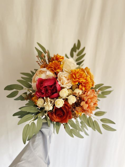 "These romantic silk wedding bouquets are made from faux flowers of rust orange , hot pink, terracotta, pale pink and light cream, sage greenery, silk eucalyptus. They will make the perfect addition to your big day!  This bridal bouquet consists of silk roses, peonies, hydrangeas and dahlias, green silk eucalyptus and sage greenery and fillers. The stems are wrapped in twine. The bridal bouquet pictured is 12\" (30 cm). Bouquet Size Available: Bridal Bouquet- 12\" (30 cm) Bridesmaids Bouquets 7\" (18 cm) Toss bouquet 6\" (15 cm) Matching bridesmaids bouquets, toss bouquet, corsages and boutonnières and other accessories are available." Terracotta Bridesmaids, Terracotta Bouquet, Rust Orange Wedding, Bridal Bouquet Peach, Orange Wedding Bouquet, Toss Bouquet, Rusting Wedding, Fall Centerpieces, Orange Bouquets