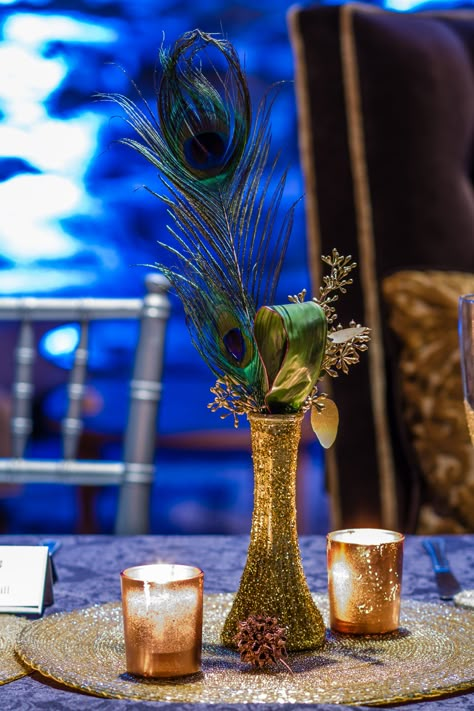 Peacock Feather with Gold Vase Centerpiece, perhaps add more white flowers -- baby breath, roses, lilies, etc. Peacock Arrangements Ideas, Peacock Feather Wedding Centerpieces, Peacock Table Decorations, Art Deco Table Centerpieces, Peacock Centerpieces Table Decorations, Peacock Decorating Ideas, Peacock Feather Centerpieces, Peacock Theme Decoration, Peacock Party Theme