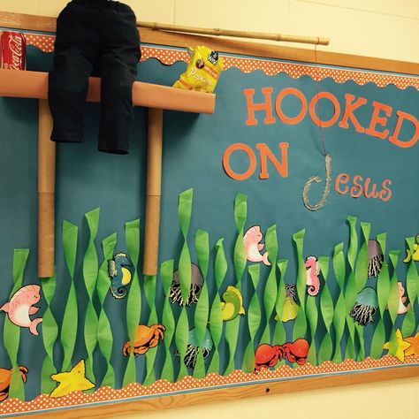 Hooked on Jesus bulletin board. We took this idea from another pin, but we made some changes of our own. So happy with the result!  #childrensministry #preschoolministry #hookedonjesus #bulletinboards #creativebulletinboards #kidmin #preschool #fishing #fish #CUTE Fishing Theme Classroom, Hooked On Jesus Bulletin Board, Fishing Bulletin Board Ideas, Fish Bulletin Board Ideas, April Door Decorations, Fish Bulletin Boards, Jesus Bulletin Boards, Classroom Jobs Bulletin Board, Ocean Bulletin Board