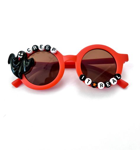 "\"CREEP IT REAL\"---HALLOWEEN SUNNIES!! These are too cute-- Each pair is handcrafted by me. Using various beads, Charms, and fun details! 🧡🖤 Be the most styling when you rock these sunglasses 😎 * Anti-Glare * UV Protection (UVA & UVB) * Durable and shatterproof  * They open and close smoothly  * Each item is made to order and will be ready to ship in 5-7 business days! If you need your order sooner. Please check out my \"RUSH ORDER OPTION\".  https://www.etsy.com/EyeCandyandFluff/listing/1286351273/rush-my-order-please *SHOP DISCLAIMER/WAIVER!  * Do NOT let your child put the sunglasses in their mouth as beads can become detached.    Always monitor and supervise while children are wearing these. The shop assumes no responsibility for sunglasses made. *Ghost charm may vary in style.  S Halloween Sunnies, Plastic Sunglasses For Halloween Party, Sunglasses With Beads On Them, Halloween Tinted Plastic Sunglasses, Halloween Sunglasses, Sunglass Design, Disguise Art, Creative Sunglasses, Birthday Sunglasses