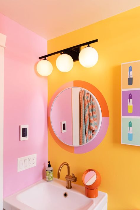 Pink and orange decal around bathroom mirror. Orange And Pink Maximalist, Yellow Orange Bathroom, Pink Yellow Bathroom Ideas, Aesthetic Colorful Bathroom, Bright Fun Bathroom Ideas, Pink Orange Yellow Bathroom, Fun Pink Bathroom, Cute Bathroom Color Schemes, Colorful Bathroom Backsplash