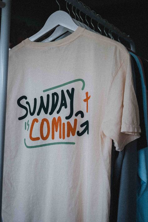 Why is Good Friday so good? Only because Sunday is coming. Based on the classic sermon about how Good Friday can be a joyful time amidst Christ's death. Printed in a retro orange, light blue, and dark teal color scheme on a heavyweight Comfort Colors tee, this high quality piece allows you to start conversation and share with others why Easter, Good Friday, and Christ's death are so integral to our faith in Jesus. Back: "Sunday Is Coming" Front: Orange Cross in upper left area Description: 6.1 o Elevated Faith Clothing, Let Your Light Shine Shirt, Bible T Shirt Design, Pastor Tshirt Ideas, School Spirit Tees, Church T Shirt Designs, Youth Group Tshirt Ideas, Church Tshirt Designs Ideas, Church Merch Display