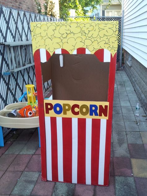 For my son's first birthday (circus theme) we decided to make a popcorn stand. We used a large cardboard box, red spray paint, white painters tape for the lines and yellow posterboard. It was easy to make and the kids loved taking pictures inside. Diy Popcorn Machine Cardboard, Carnival Popcorn Stand, Diy Popcorn Stand, Popcorn Stand Ideas, Food Booth, Deco Cinema, Popcorn Stand, Diy Popcorn, Diy Carnival