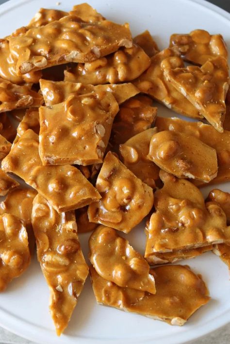 Homemade microwave peanut brittle piled up on a white plate. Microwave Peanut Brittle, Microwave Dessert, Peanut Brittle, White Plate, White Plates, Peanut, Dessert, White