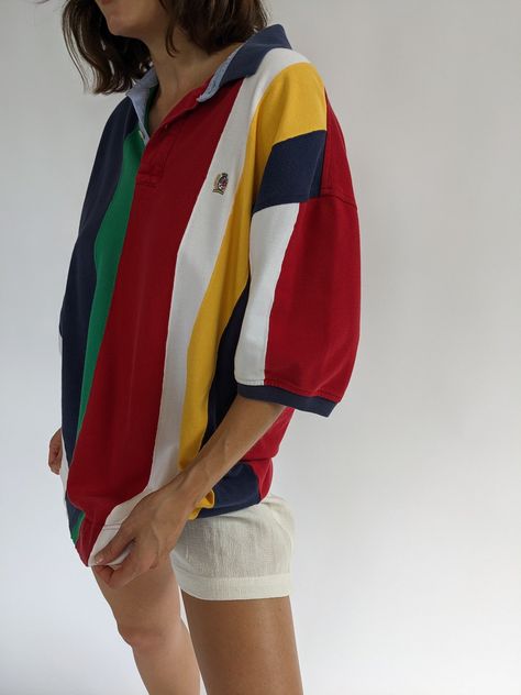 Bright & colorful striped polo by Tommy Hilfiger from the 90s. Polo has a collared neckline with button closures, short sleeves and a signature embroidered crest at the front. Tag reads Tommy Hilfiger A couple very faint darkened spots at the front lower & some speckled discoloration at the end of the left sleeve. Tommy Hilfiger Aesthetic Vintage, Tommy Hilfiger Aesthetic, Modern Yacht, Boyish Girl, 80s Shorts, Tommy Hilfiger Polo Shirt, Yeezy 700, Thrift Finds, Wide Stripes