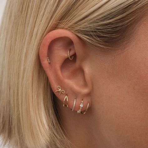 Elevate your ear game with Charlie's rope hoop mini clicker piercing. This delicate and charming earring adds a modern twist on a classic design, creating the illusion of gently winding through your lobes. Perfect for everyday wear and crafted in solid 14 karat gold, it's a must-have for any earring collection. Classy Ear Stack, Delicate Piercings Ear, Pericings Name, Minimal Ear Stack, Earring Piercing Chart, Ear Inspo Jewelry, Ear Piercings Dainty, Delicate Ear Piercings, Piecing Ear