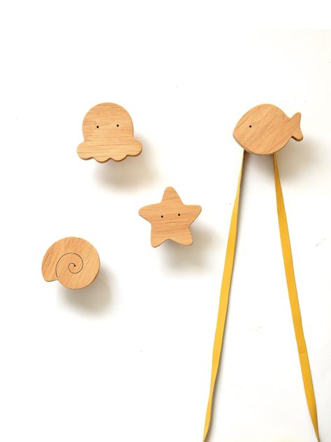 "Decorative, ocean-themed, wooden wall hooks. A playful and useful addition to the nursery, children's room, or entryway.  Ideal for hanging children's clothing, caps, bags, accessories, etc.  Choose from 6 underwater characters: Octopus, Whale, Jellyfish, Fish, Sea Star, and Shell. This listing is for 1(one) wall hook. SIZE:   3-2.4'' (7,5-6 cm) x 2.8-2.4'' (7-6cm) Measure from the wall (hanging part) 1.6\" (4cm)  EASY TO INSTALL: The hook comes with a screw and a wall anchor. Just drill the wa Aquatic Themed Nursery, Ocean Themed Nursery Target, Deep Sea Nursery Ideas, Underwater Nursery Theme Girl, Life Aquatic Nursery, Nursery Wall Hooks, Kids Wall Hooks, Ocean Themed Nursery, Beach Nursery