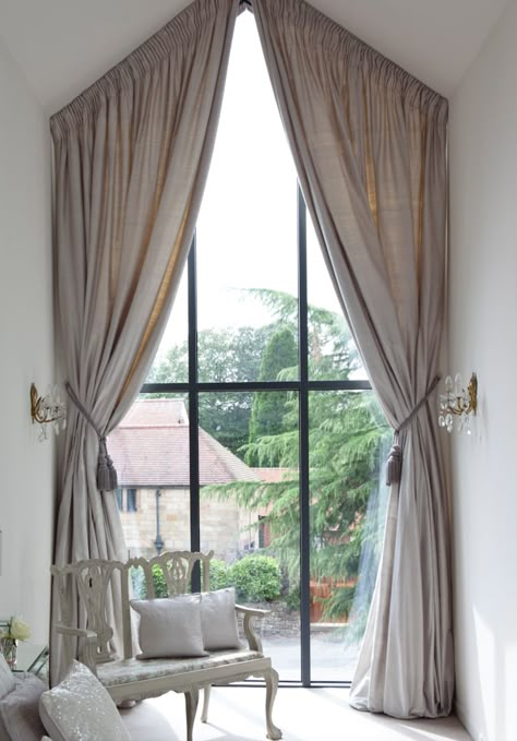 Bespoke curtains created for the clients high arched feature window in this stunning bedroom.
(using a scaffold tower and a steady hand to hang them!) Dormer Window Curtain Ideas, Angle Window Curtains, Curtains On Angled Ceiling, Curtains For Angled Windows, Angled Window Treatments, Curtains Vaulted Ceiling, Angled Curtains, Apex Window Curtains, Triangle Window Curtains