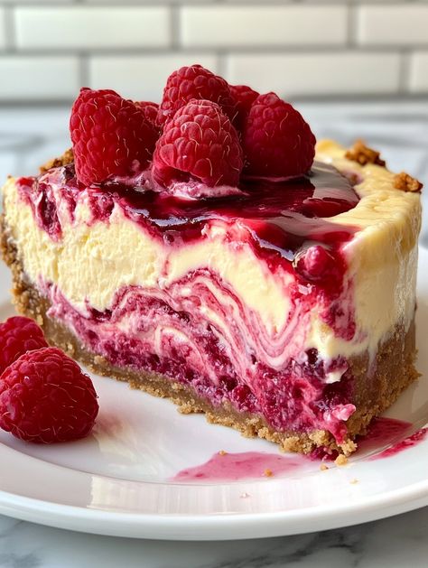 Lemon Raspberry Swirl Cheesecake with a Surprise Center 🍋   𝗜𝗻𝗴𝗿𝗲𝗱𝗶𝗲𝗻𝘁𝘀 👍  - 2 cups graham cracker crumbs - 1/2 cup unsalted butter, melted - 4 (8 oz) packages cream cheese, softened - 1 1/4 cups granulated sugar - 1 teaspoon vanilla extract - 4 large eggs - 1/2 cup sour cream - 1/4 cup heavy cream - Zest of 2 lemons - 1/4 cup fresh lemon juice - 1/2 cup raspberry jam, warmed - 1 cup fresh raspberries - 1 cup white chocolate chips Fresh Raspberry Desserts, Raspberry Lemon Cheesecake, Raspberry Swirl Cheesecake, Swirl Cheesecake, Best Cake Ever, Fresh Raspberries, Lemon Raspberry, Sweet Snacks Recipes, Raspberry Jam